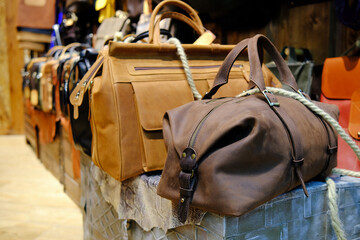 Men's accessories with brown leather bags on wooden table over wall background
