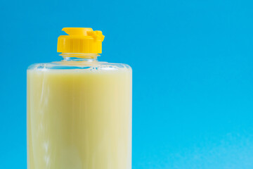 Dishwashing liquid in a transparent plastic package on a blue background. The concept of ecological detergents and environmental protection