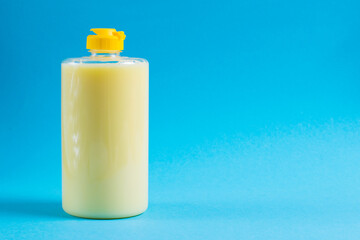 Dishwashing liquid in a transparent plastic package on a blue background. The concept of ecological detergents and environmental protection