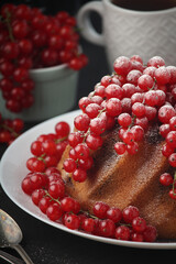 A cake with fresh red currant and tea	