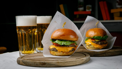 American cuisine. Meat burger with beer on a white table.
