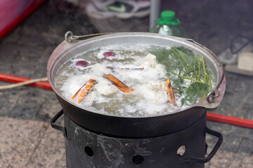 A cauldron in which fish soup is cooked with different ingredients