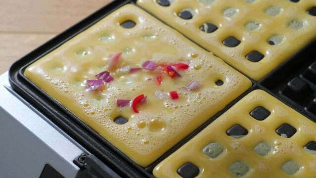  chef adds spices and onions and vegetables to an omelet cooked in an automatic toaster. High quality 4k footage