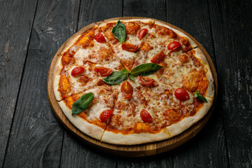 Italian cuisine. Pizza on a black table
