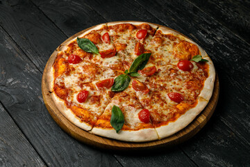 Italian cuisine. Pizza on a black table
