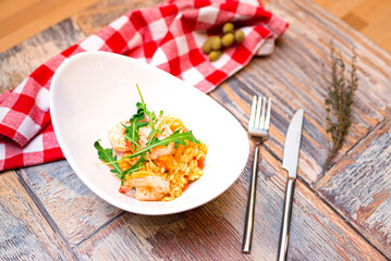 A portion of risotto with shrimp, seafood and arugula in a deep boat plate