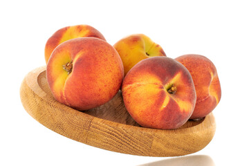 Several sweet organic peaches on a wooden tray, close-up, isolated on a white background.