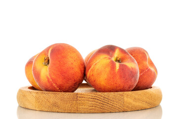 Several sweet organic peaches on a wooden tray, close-up, isolated on a white background.