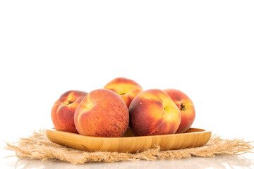 Several sweet organic peaches on a wooden tray, close-up, isolated on a white background.