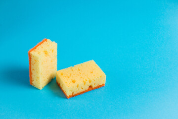 Yellow porous sponges for cleaning on a blue background with copy space. Home cleaning concept