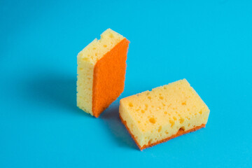 Yellow porous sponges for cleaning on a blue background with copy space. Home cleaning concept