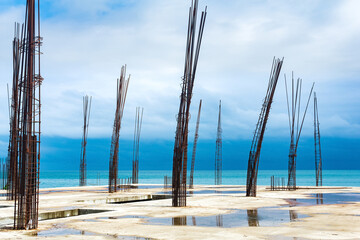 unfinished building with protruding rebar on the seashore