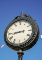 Fototapeta na wymiar clock in English Town. ornate timepiece in centre of town square. 