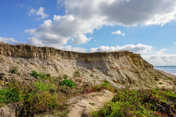 Rugged cliff on coastal region of UK. Eroded sea cliff behind public beach. weather and elements...