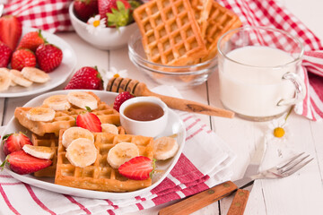 Waffles with strawberries, bananas and honey.