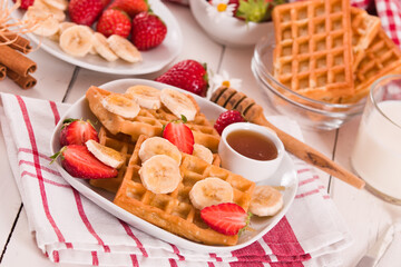 Waffles with strawberries, bananas and honey.