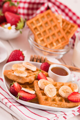 Waffles with strawberries, bananas and honey.