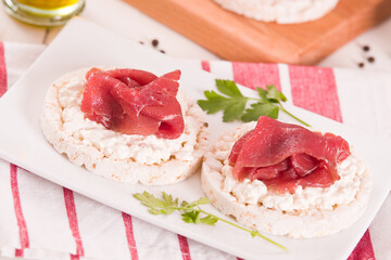 Rice cakes with milk flakes and cold beef.