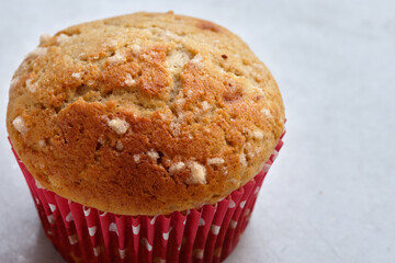freshly baked cupcake with colorful wrapper, on white background with copy space