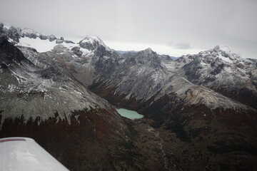 the photo captures the moment of takeoff and flight by plane over Ushuaia — a city and port in...