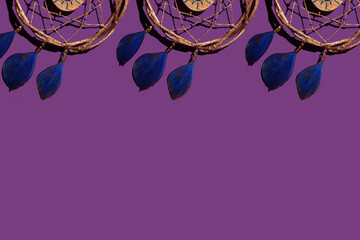 wooden dream catcher with feathers on a purple background