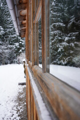 Snowy winter mountain with a cozy hutwindow reflections