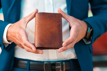 A businessman in an elegant blue jacket and white shirt shows off a leather brown cover for...