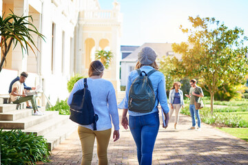 On our way to class ready to learn. Rearview shot of unrecognizable university students walking to class on campus.