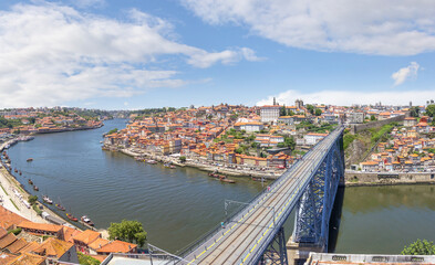 Fototapeta na wymiar Embankment Ribeira in old town, the Dom Luis I Bridge and Douro river, cityscape. Porto, Portugal