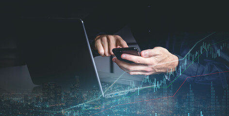 Plan growth and increase of positive indicators in his business. Hand touch white tablet with digital hologram growth graph chart sign on city dark blurred background. Investment business onlin