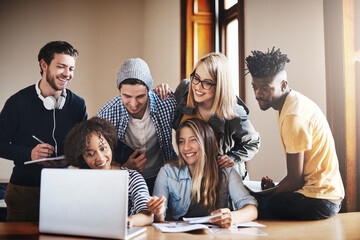 Bringing our ideas together for a better assignment. Cropped shot of a group of university students working on an assignment together in class.