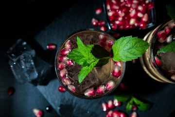 Two summer drinks with pomgranate, mint and some sugar. flat lay and black background
