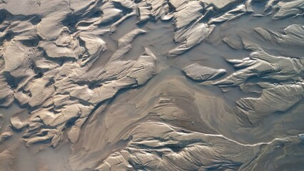 Dirty wet sand, grunge horizontal shabby background close-up. Blurry image of sand pattern. Abstract nature background.