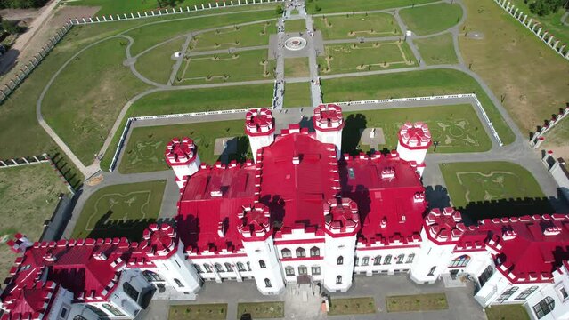 Aerial view of Kossovo castle with beautiful red roof. Restored ancient castle-palace of Paslovsky Kosovo, Belarus. Construction aerial view height