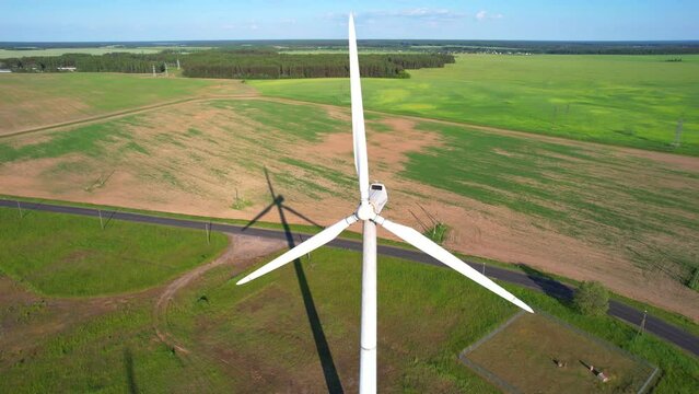 Aerial view of windmill in rural landscape. Aerial drone shot of fast spinning wind turbine