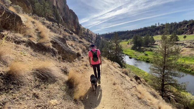 Male hiker with dog on trail in Smith Rock State Park
