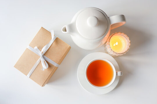 Tea, teapot and candle on a white background. Cozy warm photo