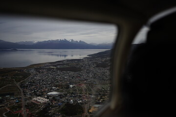 the photo captures the moment of takeoff and flight by plane over Ushuaia — a city and port in southern Argentina.