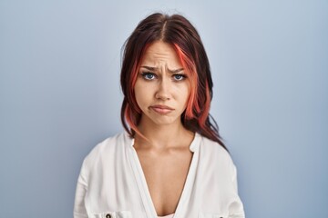 Young caucasian woman wearing casual white shirt over isolated background depressed and worry for...