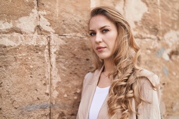 Fototapeta premium Young blonde woman with relaxed expression standing at park
