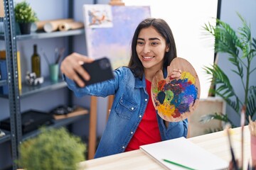 Young hispanic girl artist make selfie by smartphone at art studio