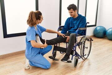Young disabled man making mobility exercise sitting on wheelchair at the clinic.