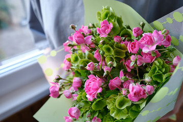Bouquet of pink beautiful roses in the hands of a woman. Stylish flowers in the hands of a florist. The girl collected a fresh bouquet in pink and green shades. Beautiful delicate flowers. holiday gif