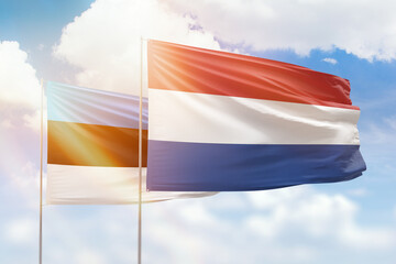 Sunny blue sky and flags of netherlands and estonia