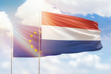 Sunny blue sky and flags of netherlands and european union