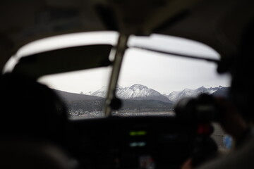 the photo captures the moment of takeoff and flight by plane over Ushuaia — a city and port in southern Argentina.