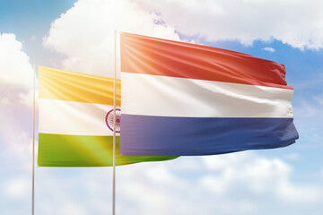 Sunny blue sky and flags of netherlands and india