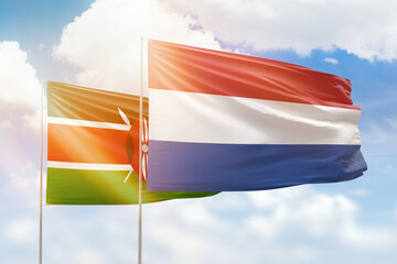 Sunny blue sky and flags of netherlands and kenya