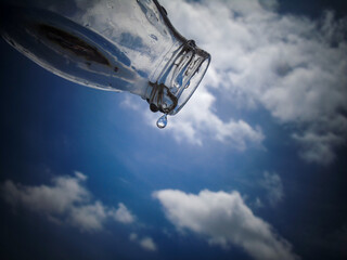 La ultima gota de una botella de vidrio, botella de vidrio dejando caer la ultima gota de agua