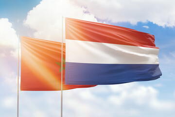 Sunny blue sky and flags of netherlands and morocco
